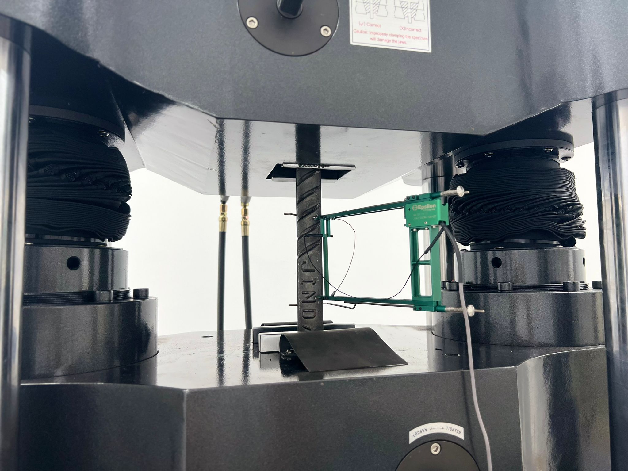 Extensometer measuring strain on a reinforcement bar during tensile testing